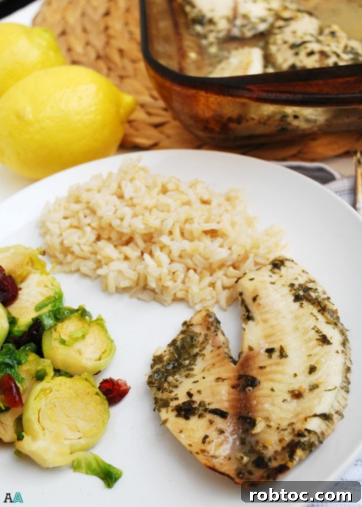 Plated Lemon Garlic Tilapia with rice and fresh parsley garnish