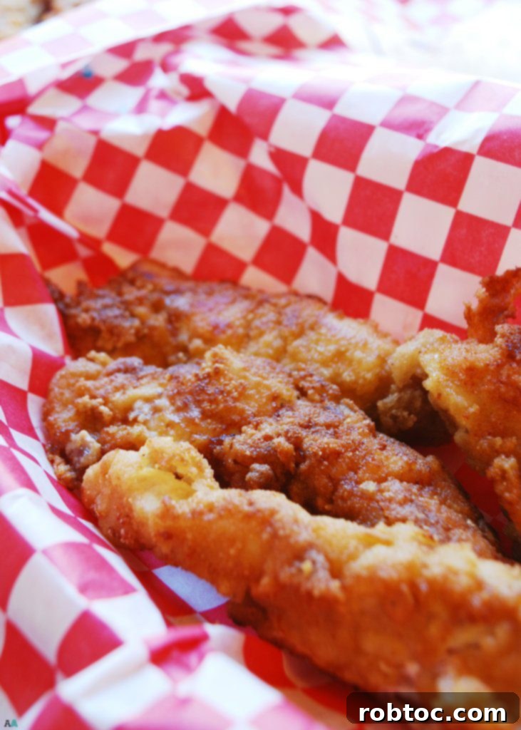 Close-up of golden-brown, allergy-friendly fried chicken pieces ready to be served. Made with a unique gluten-free breading.