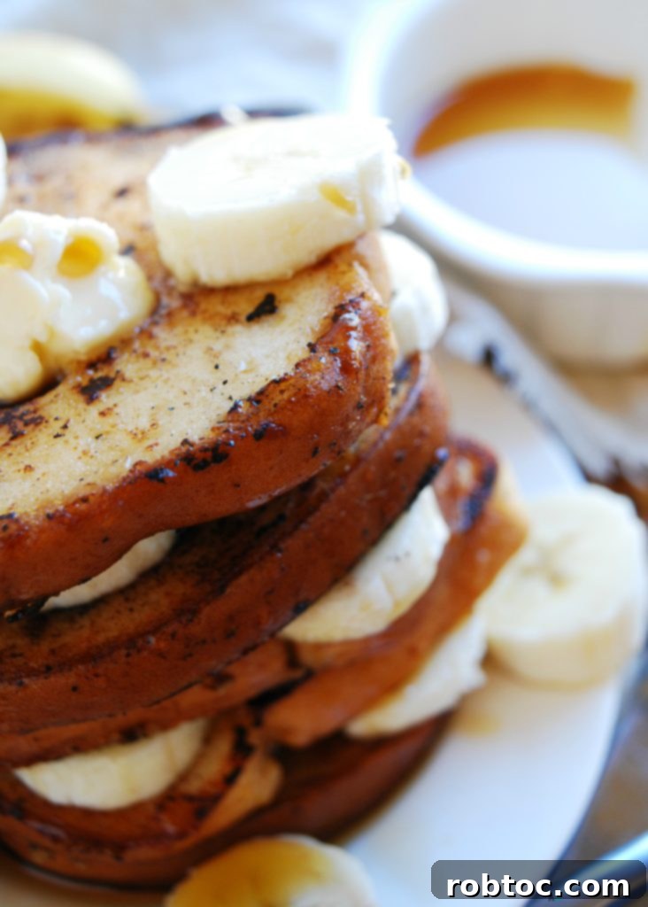 Close-up of golden-brown vegan banana French toast slices on a griddle, showing proper cooking technique. Recipe by AllergyAwesomeness.com