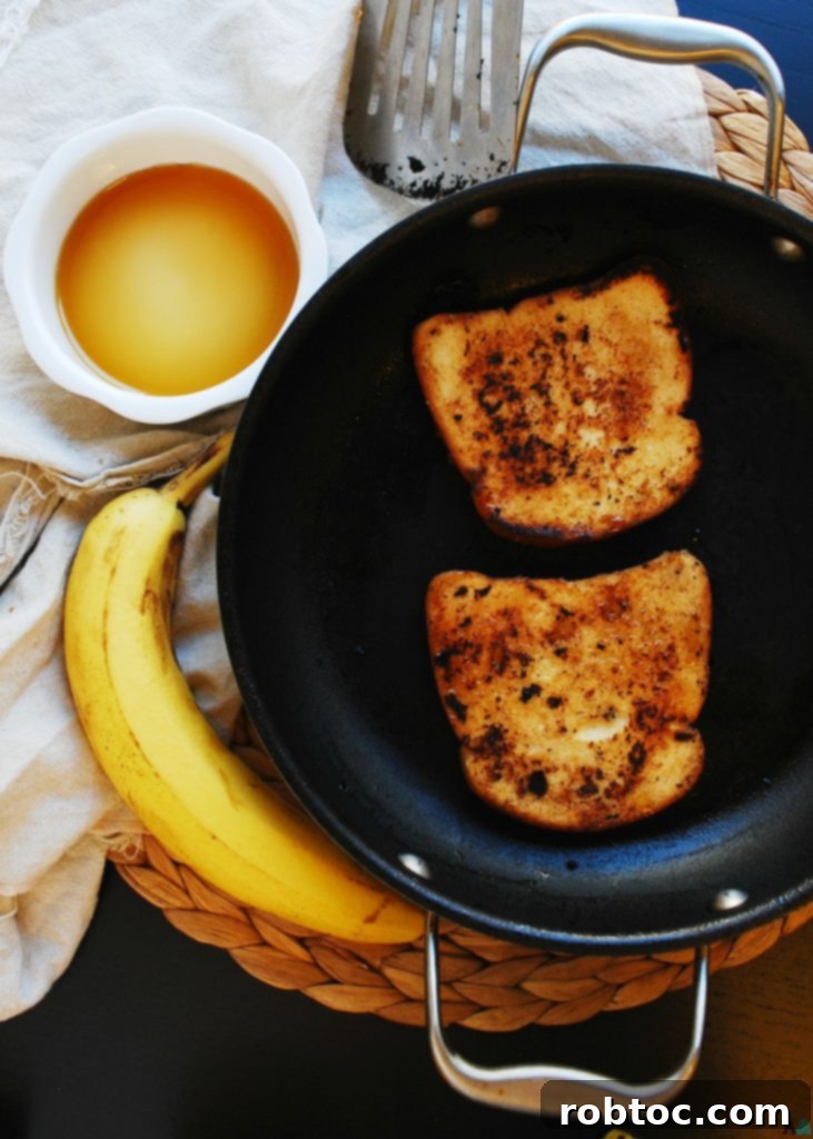 Close-up of golden-brown vegan banana French toast slices, stacked and ready to serve with toppings. Recipe by AllergyAwesomeness.com