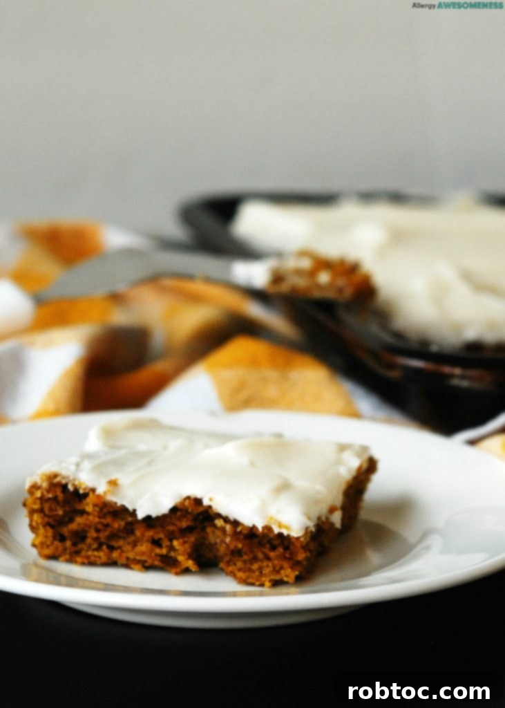 vegan-gluten-free-carrot-cake-slice-on-a-plate-with-the-sheet-cake-in-the-background