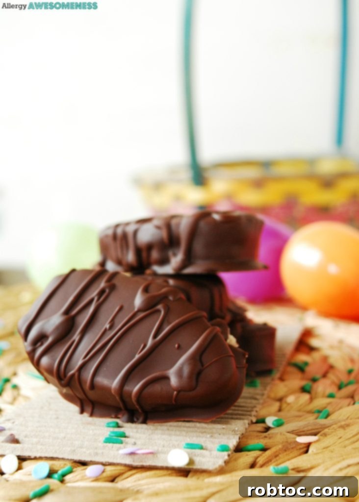 Close-up of three chocolate-covered cookie dough Easter eggs on a light pink background
