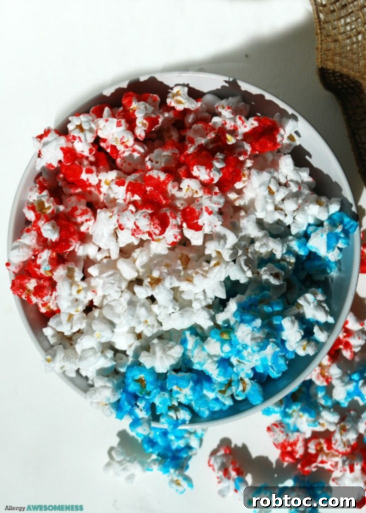 Red White and Blue Popcorn: 3 Easy Ingredients, Allergy Safe 2 Patriotic Popcorn Recipe, a vibrant red, white, and blue snack perfect for Fourth of July celebrations, on a white background.