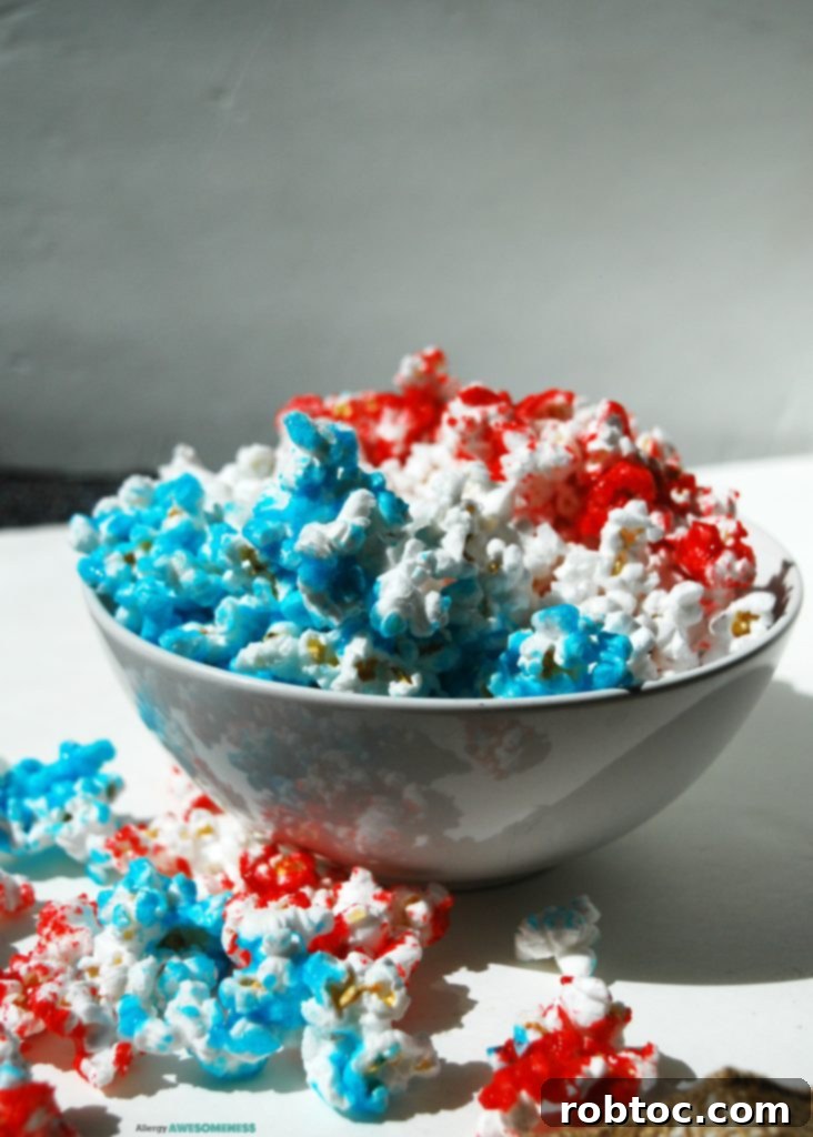 Red White and Blue Popcorn: 3 Easy Ingredients, Allergy Safe 8 Overhead view of a bowl of Red, White & Blue Popcorn Recipe, perfectly arranged for a festive occasion.