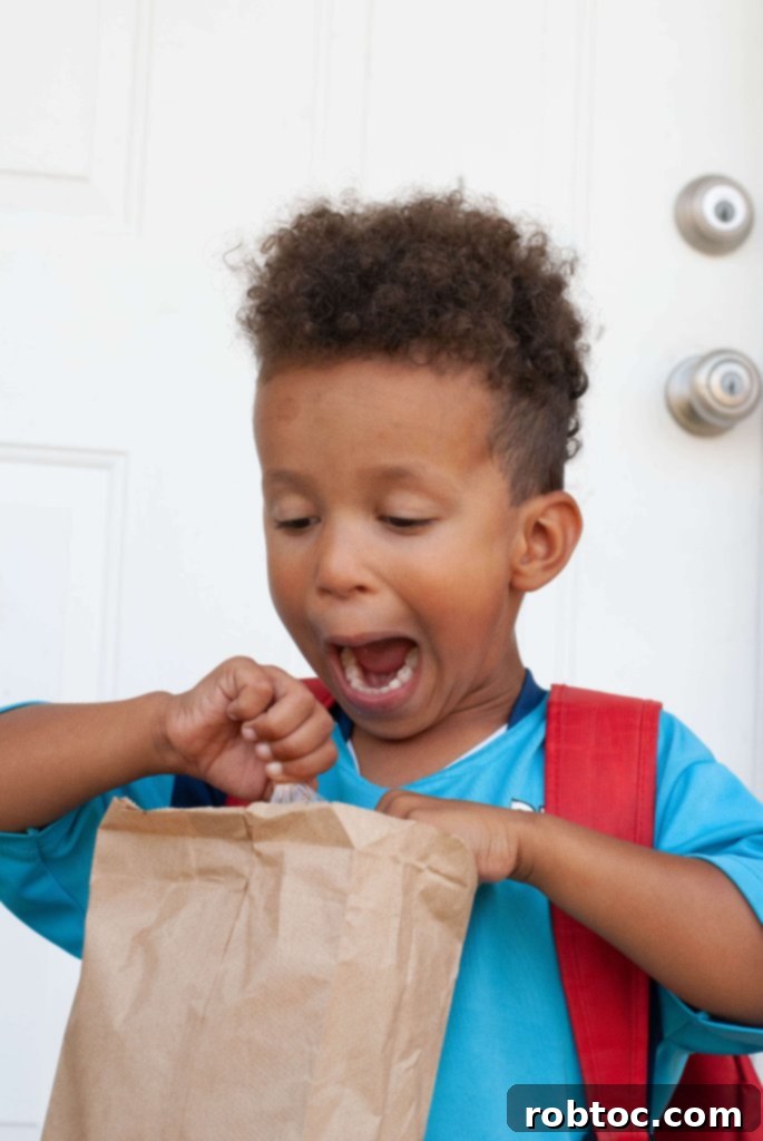A child showing an excited face, looking forward to opening their school lunch packed with safe and delicious treats.