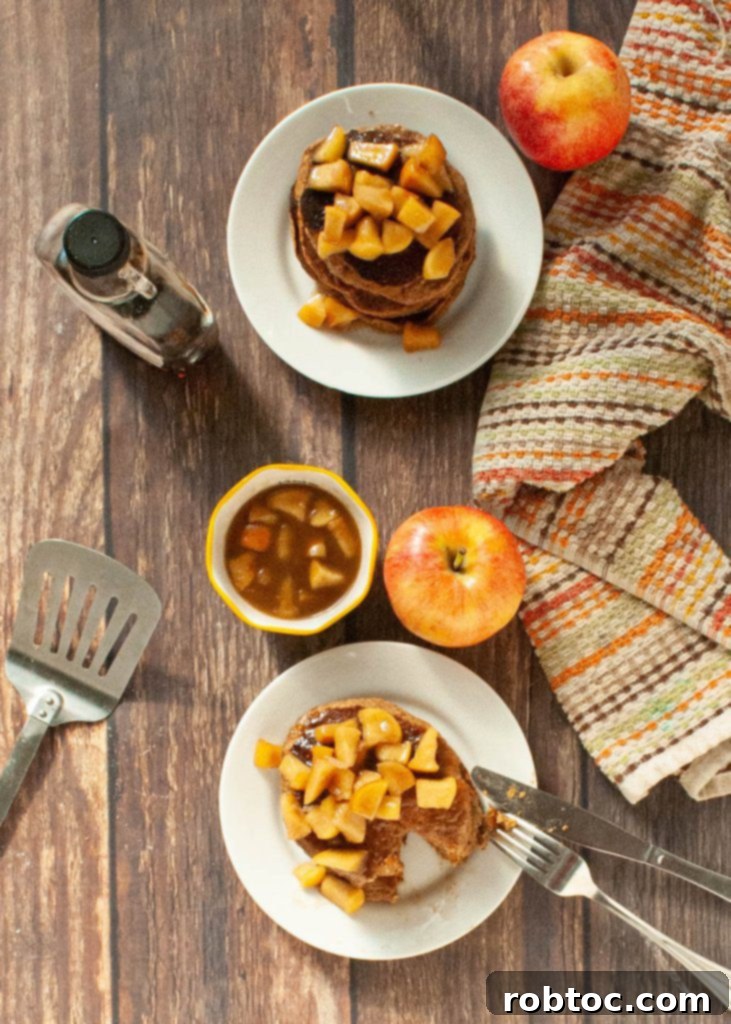 A stack of spiced apple cinnamon oatmeal pancakes with a drizzle of maple syrup and a sprinkle of cinnamon.