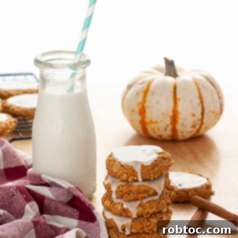 gluten-free-dairy-free-iced-pumpkin-oatmeal-cookies-stacked-by-milk-and-a-mini-pumpkin