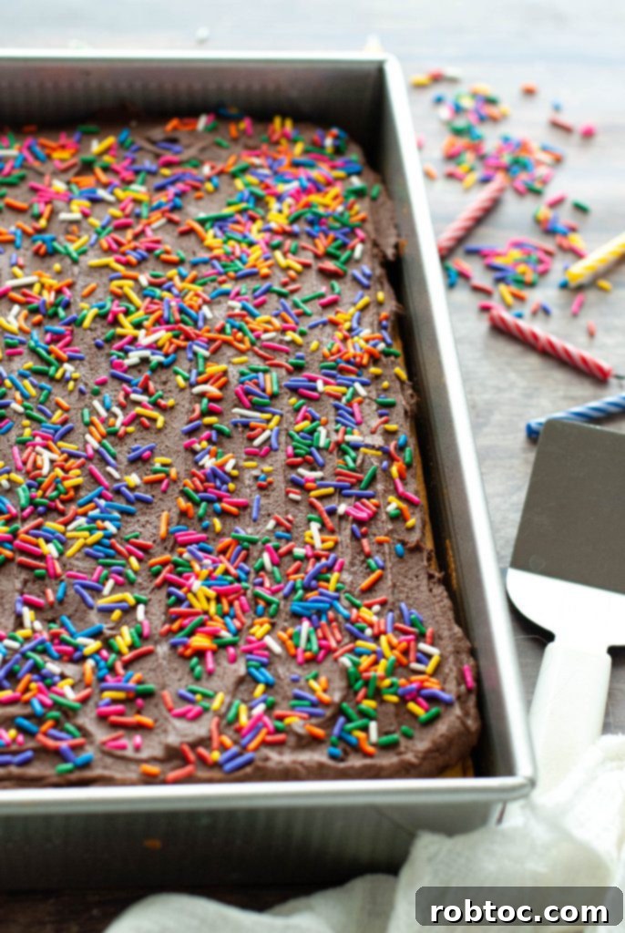 Close-up shot of an allergy-friendly yellow cake in a baking pan, decorated with colorful sprinkles.