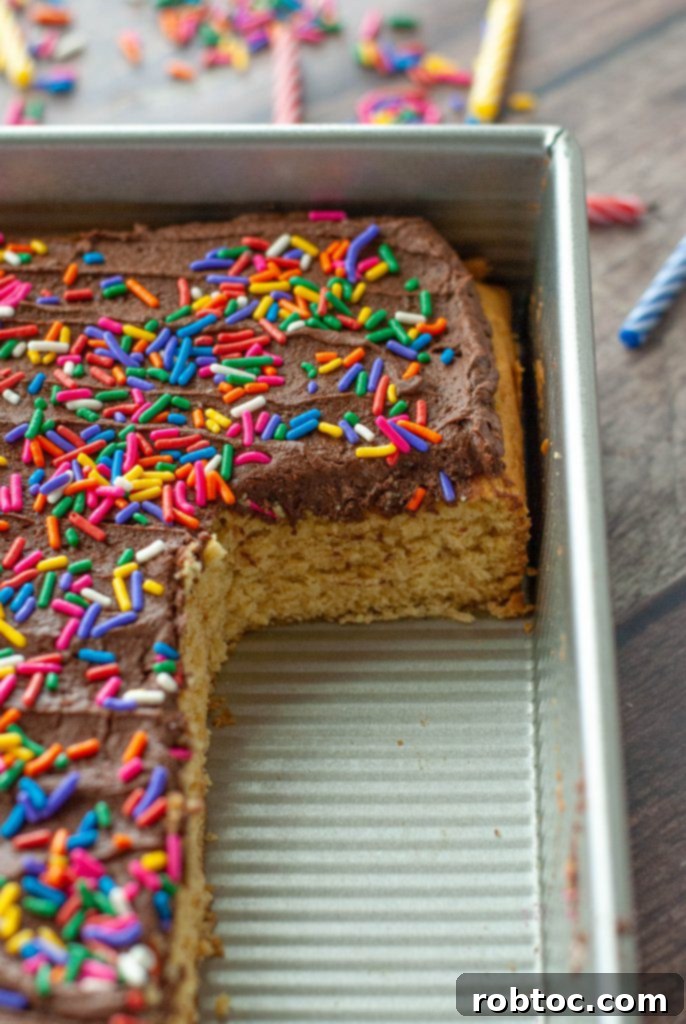 A vegan gluten-free yellow cake in a baking pan, showing a section where slices have been removed.