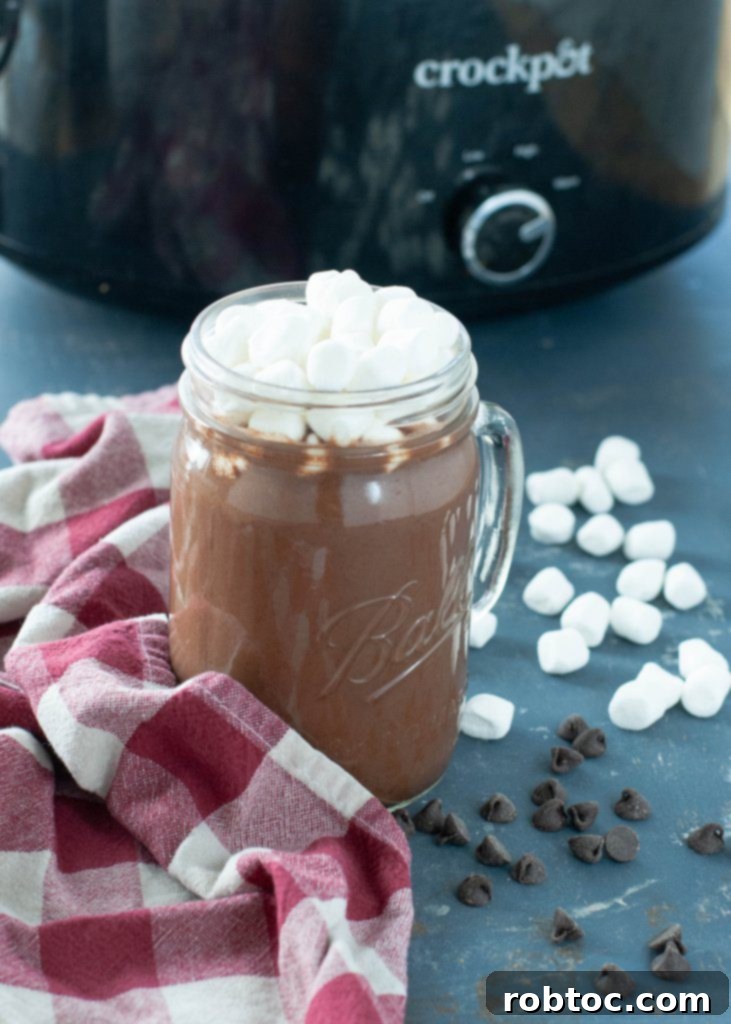 Deliciously rich and creamy dairy-free slow cooker hot chocolate, garnished with marshmallows in a mug.