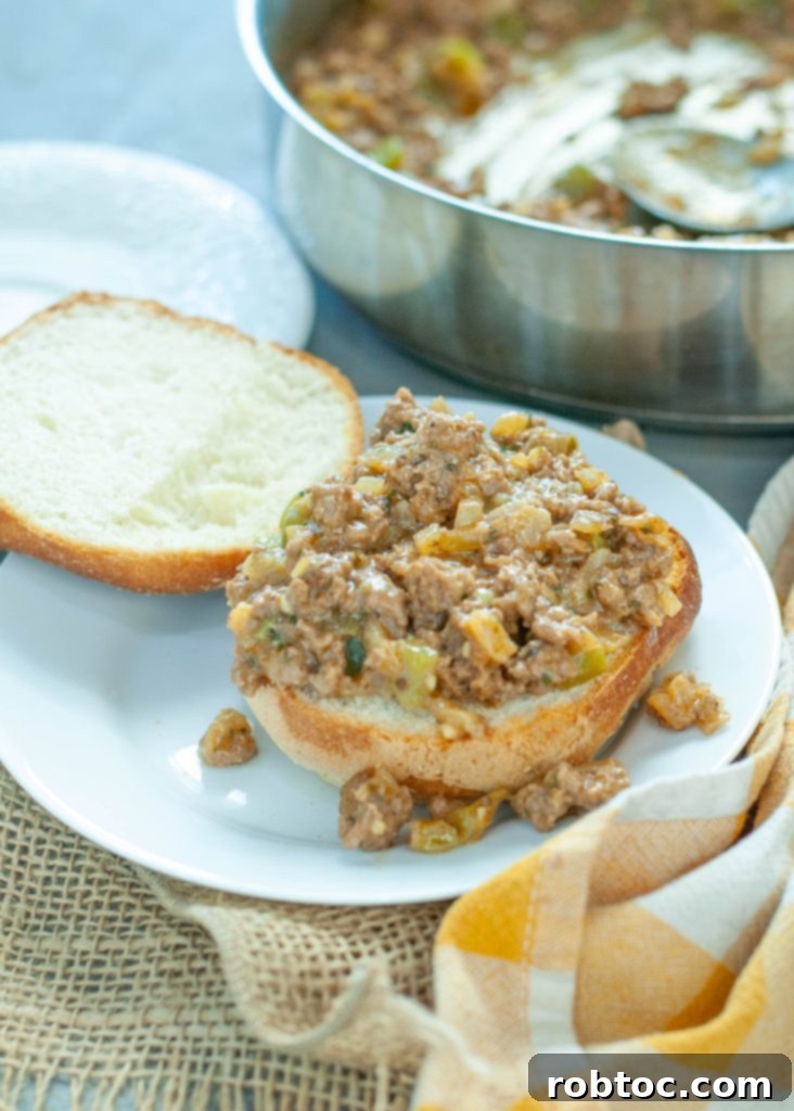 open faced philly cheesesteak sloppy joe on a white plate