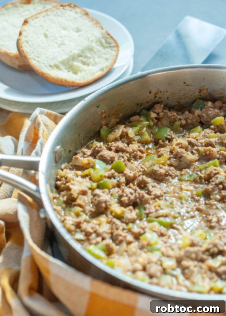 philly-cheesesteak-sloppy-joe-mixture-in-a-skillet-with-a-bun-sitting-to-the-side