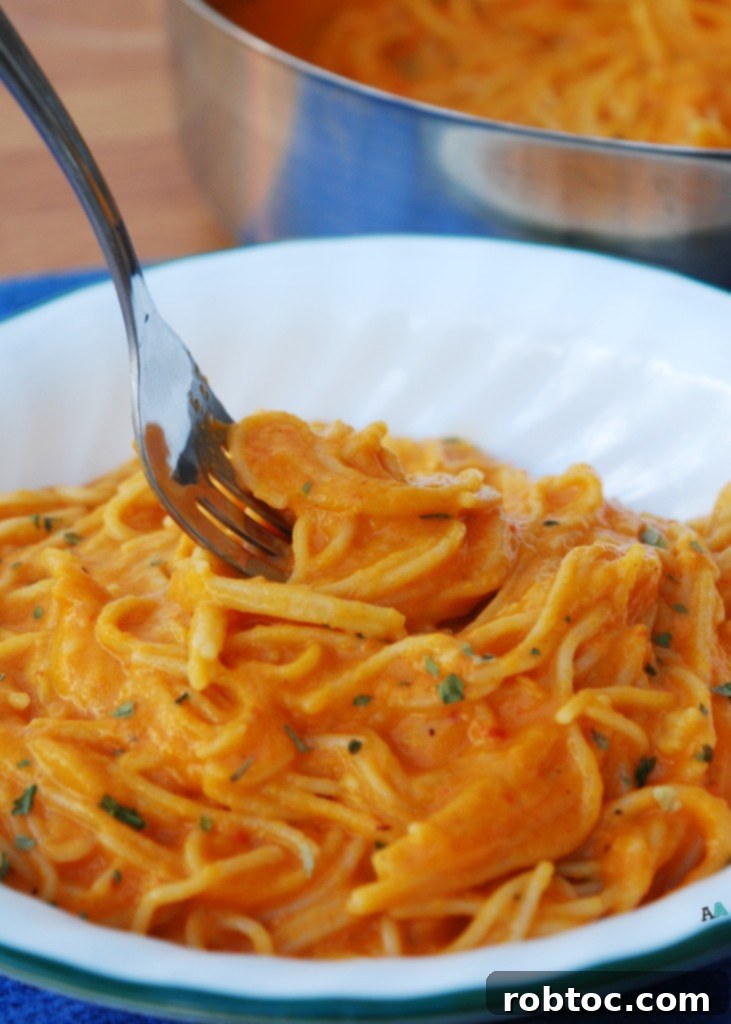 Vibrant Red Pepper Pasta Top 8 Allergen Free and Vegan 3 Bowl of roasted red pepper pasta with a fork, highlighting the creamy texture and rich color