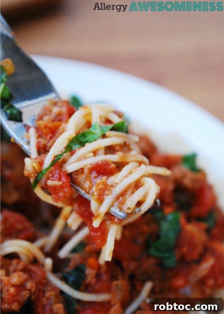 Slow Cooker Bolognese: Made for Everyone 5 Close-up of a fork lifting gluten-free pasta smothered in creamy slow cooker bolognese.