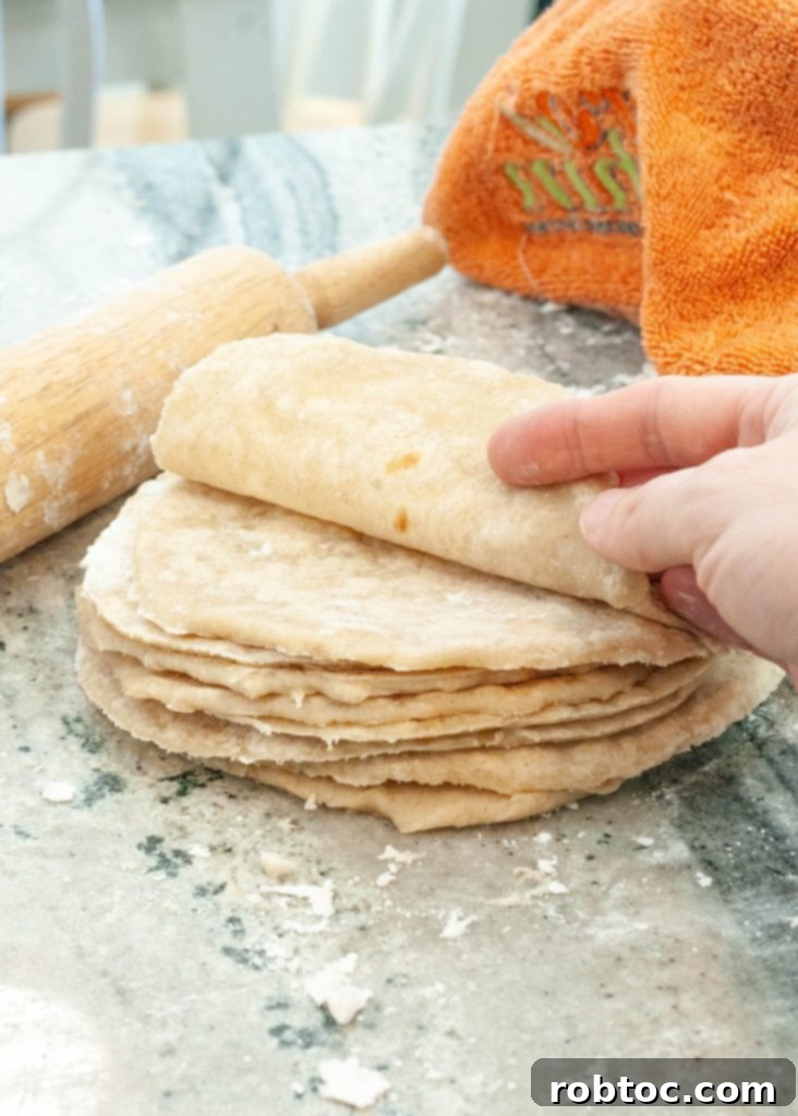 Delicious and pliable homemade gluten-free flour tortillas stacked on a board