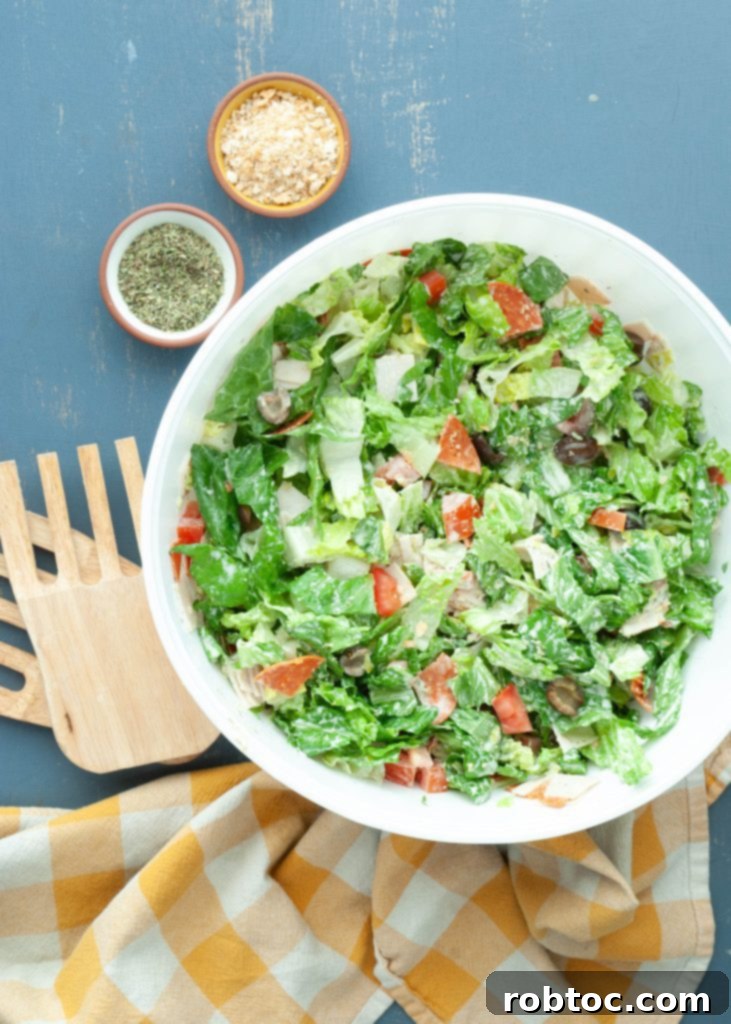 overhead shot of a dairy-free, gluten-free Italian chopped salad in a large white serving bowl, ready to be mixed