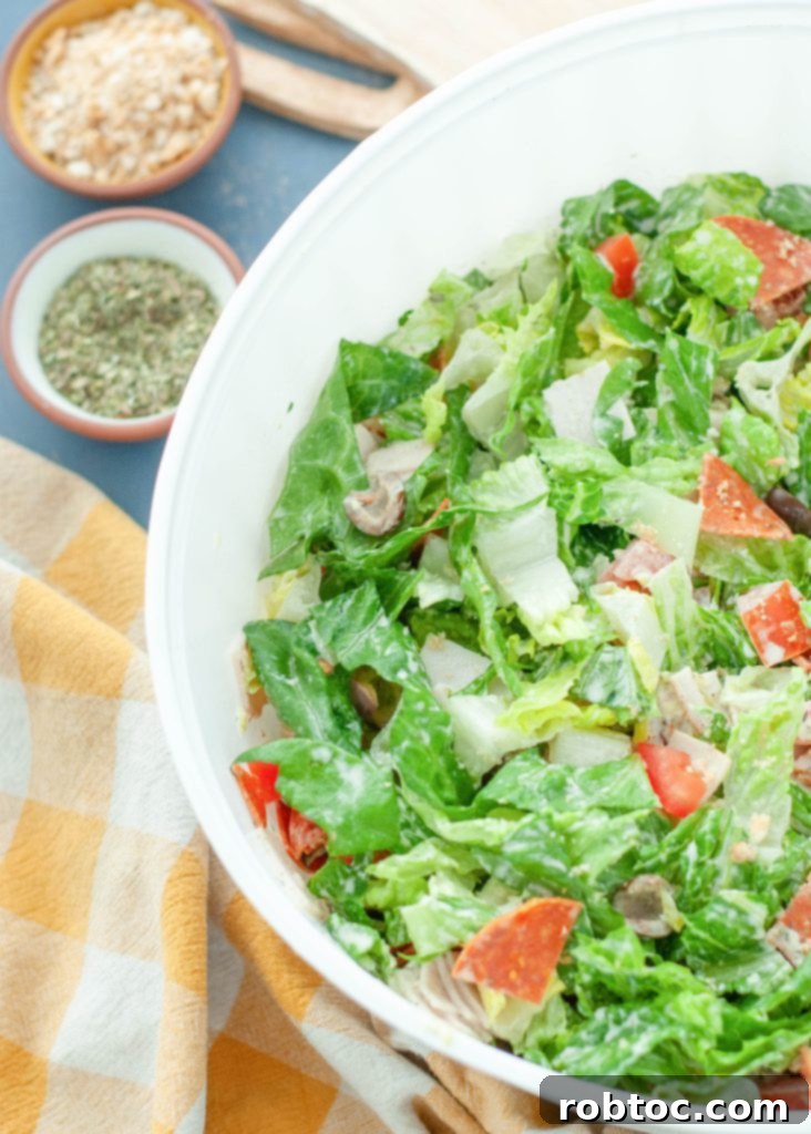 creamy Italian green salad generously coated in dressing, presented in a large white serving bowl