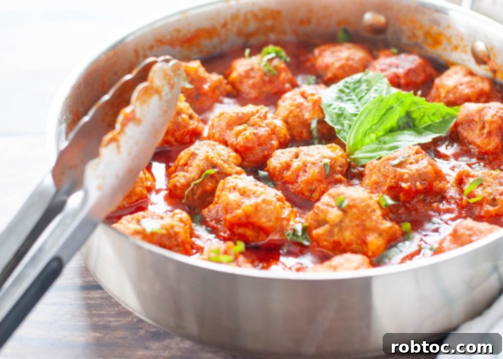 Flavorful gluten-free meatballs simmering in rich marinara sauce in a skillet, ready for an Italian dinner