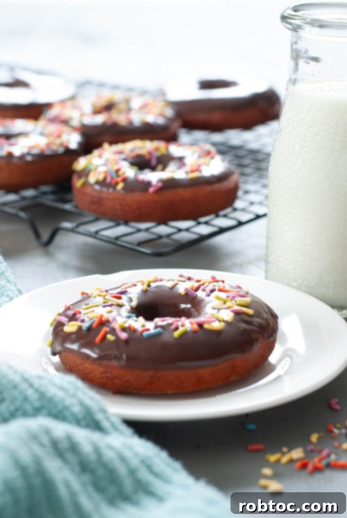 gluten-free-donut-with-chocolate-glaze-and-sprinkles-on-a-white-plate-next-to-milk
