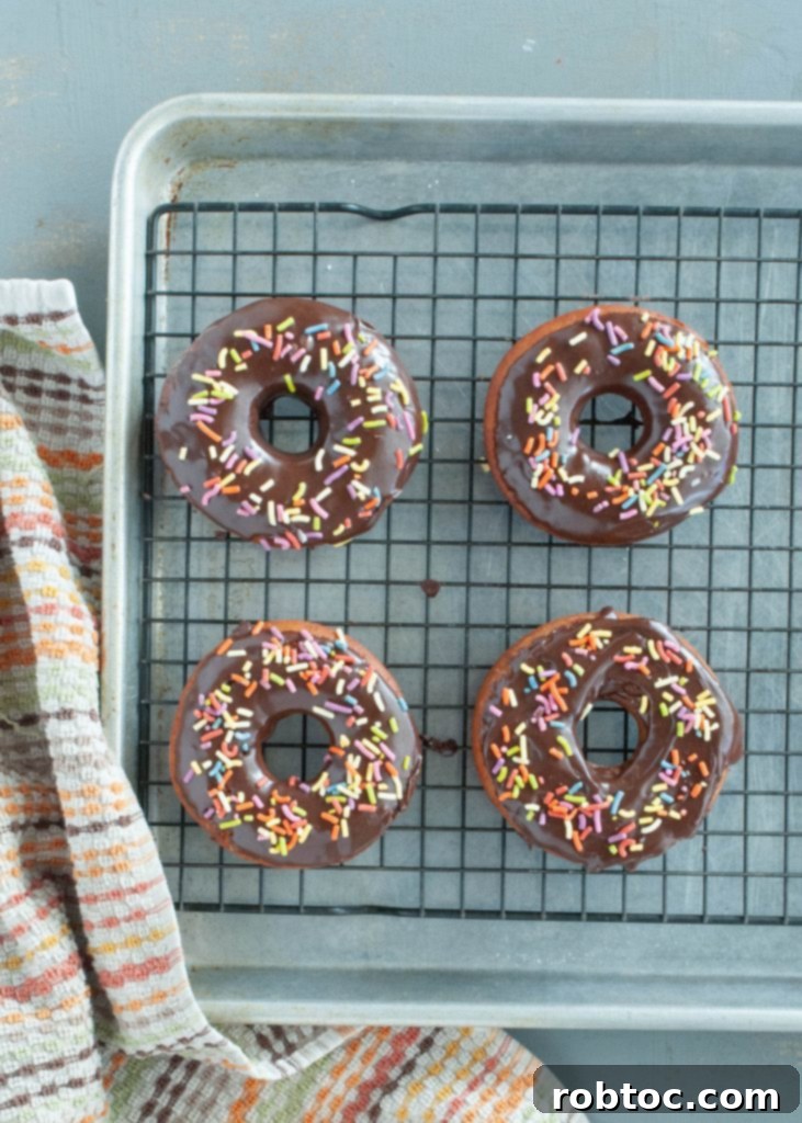 Gluten-free donuts with sprinkles cooling on a rack