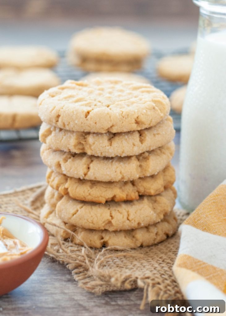 Easy Gluten-Free Peanut Butter Cookies 2 A close-up shot of several soft and chewy gluten-free peanut butter cookies on a cooling rack, showcasing their golden-brown edges and classic crosshatch pattern.
