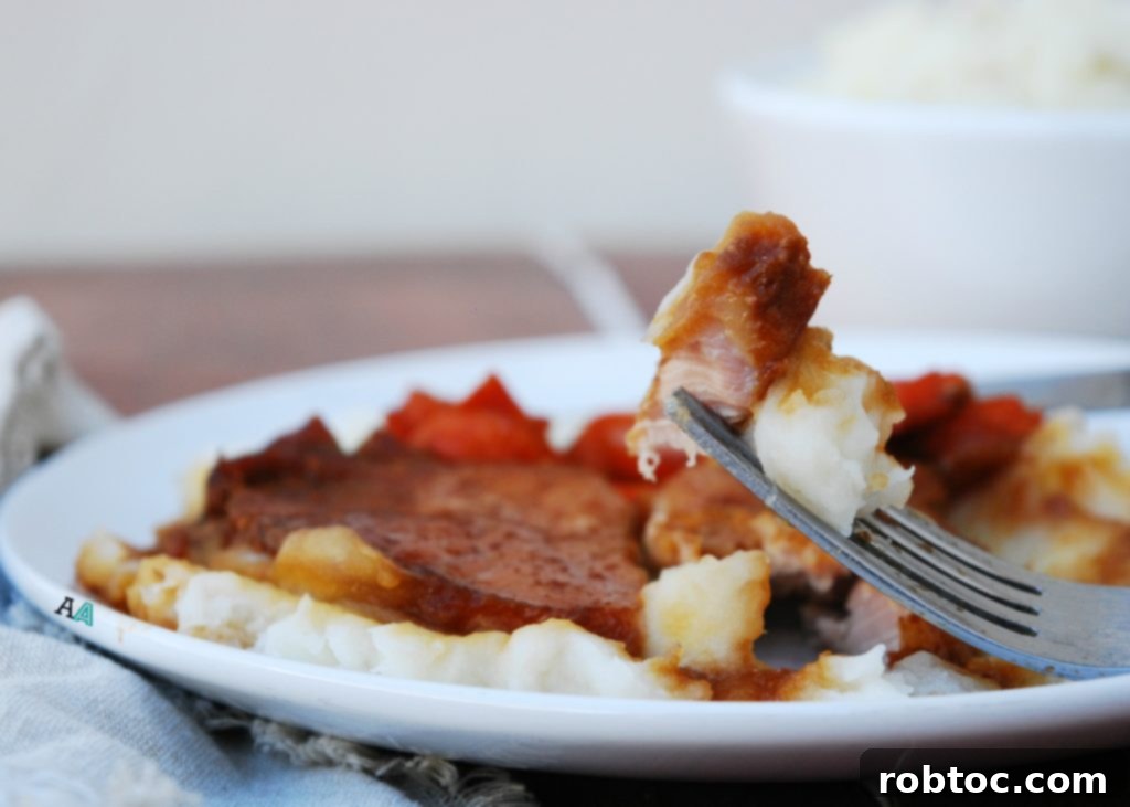 Close-up of tender San Francisco pork chops and carrots drenched in a savory glaze, ready to be served from the slow cooker.