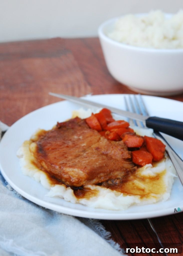 Another perspective of the Slow Cooker San Francisco Pork Chops, emphasizing their golden-brown glaze and tender texture.