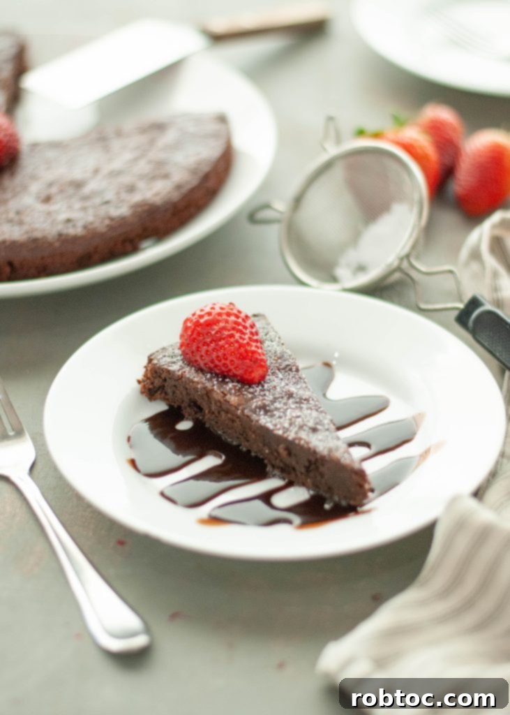 flourless-chocolate-tort-eslice-sitting-on-top-of-chocolate-sauce-with-strawberry-on-top