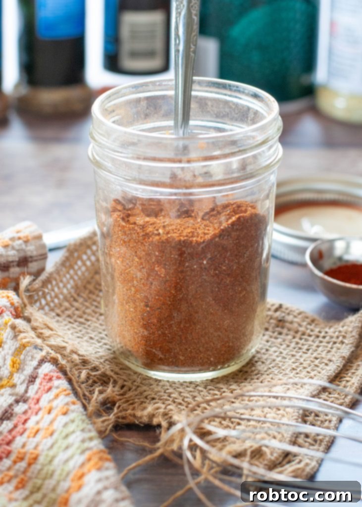 taco-spice-blend-in-jar-with-spoon-in-it-with-spices-behind-it