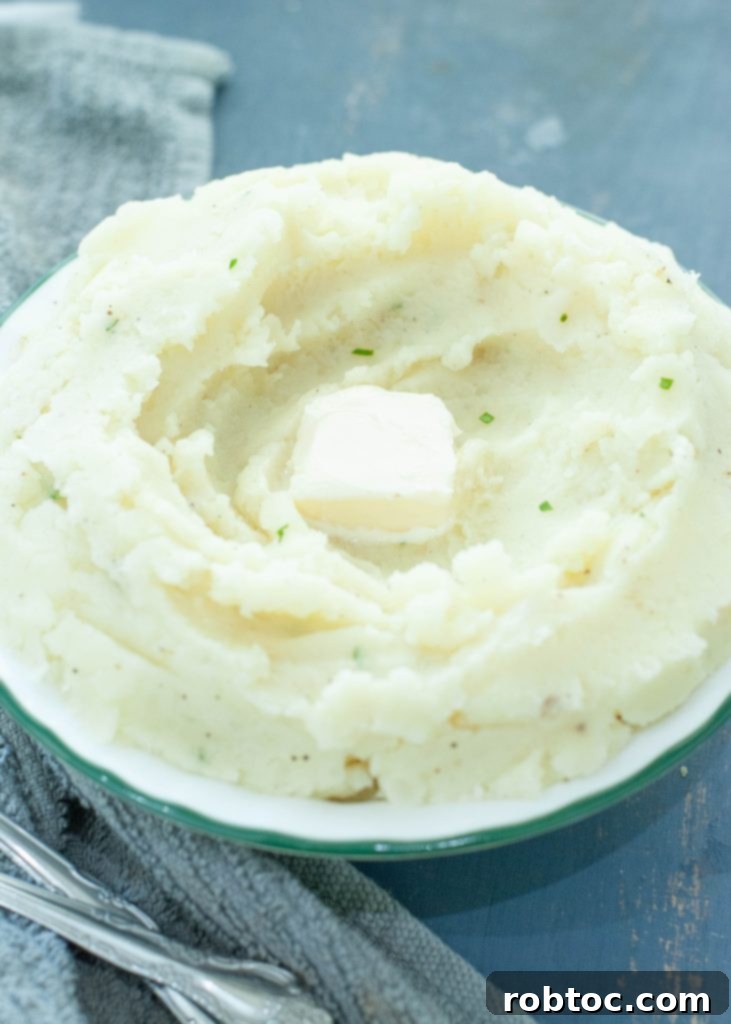 Creamy Dairy-Free Mashed Potatoes Secret Ingredient Video 6 close up of dairy-free mashed potatoes in a round bowl with a pat of dairy-free butter on top