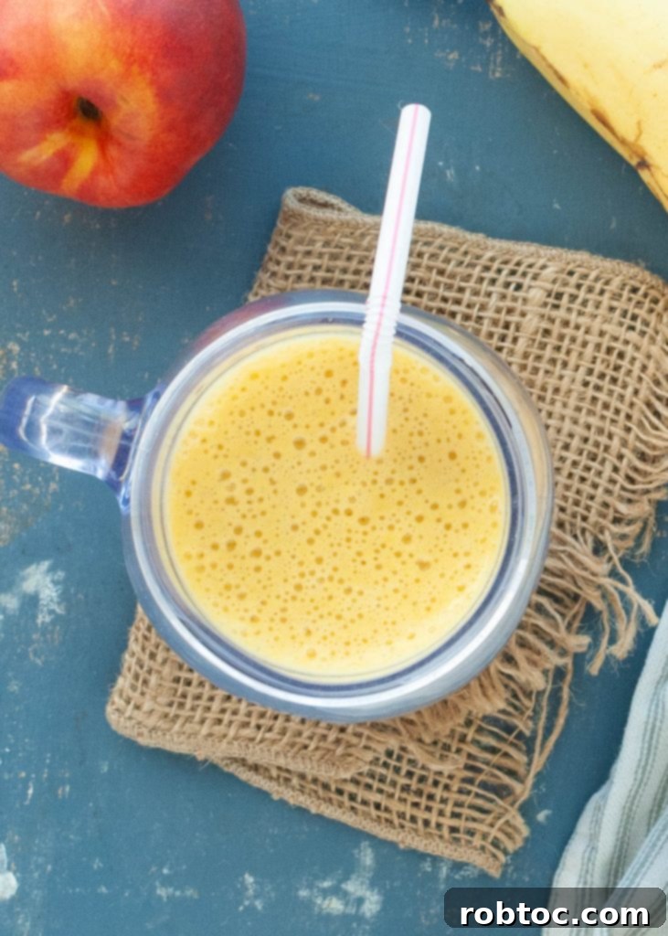Close-up of a dairy-free peach protein shake with a straw, showing its smooth texture and refreshing appeal.