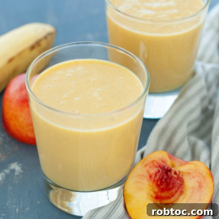 dairy-free peach protein smoothie in two glasses with fruit around it