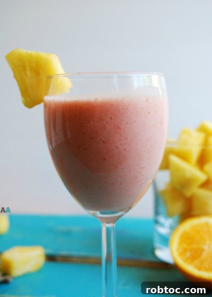 Tropical Miami Vice Smoothie in a glass, garnished with pineapple