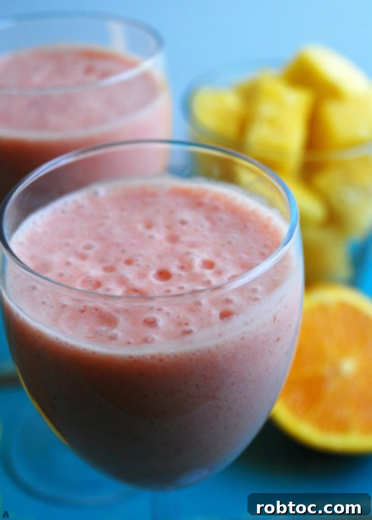 Two glasses of Miami Vice Smoothie with fresh pineapple garnish